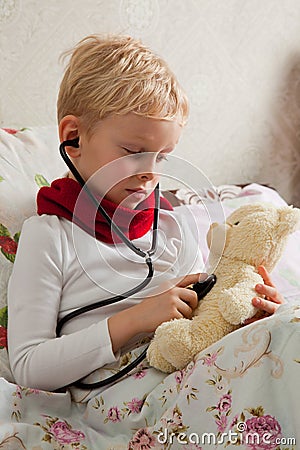 Sick boy is playing with a stethoscope