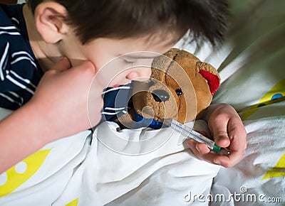 Sick child in bed with teddy bear