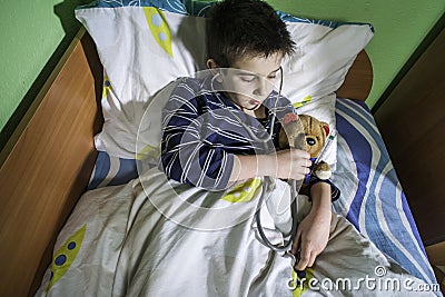 Sick child in bed with teddy bear