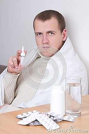 Sick man showing nasal spray in living room