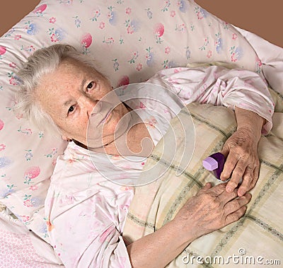 Sick old woman lying at bed