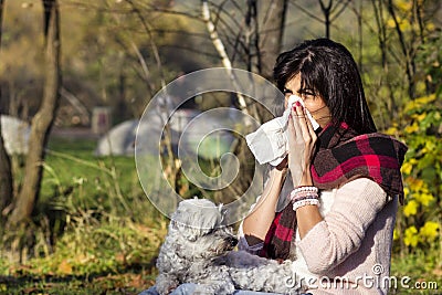 Sick woman relaxing in the autumn park with her dog