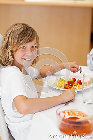 Side view of smiling boy at the dinner table