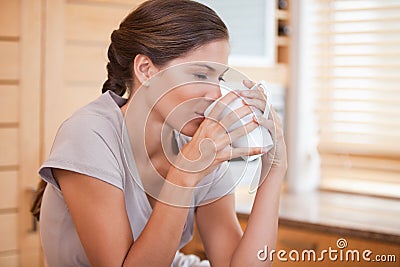 Side view of woman enjoying a cup of coffee