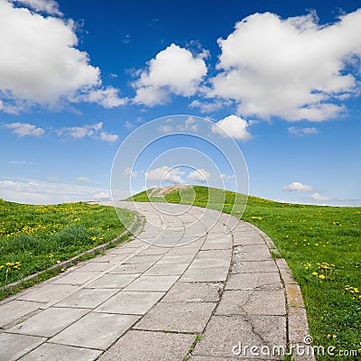 Sidewalk on green grass with blue sky