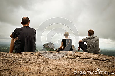 Three people sitting on Sigirya rock