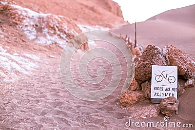 A sign says no bikes are allowed on the dune, moon valley, atacama desert