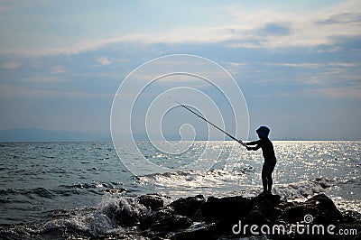 Silhouette of boy fishing