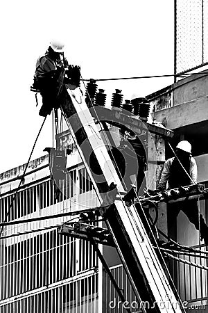 Silhouette electrician working on electricity post