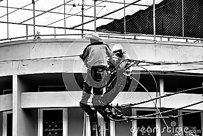 Silhouette electrician working on electricity post