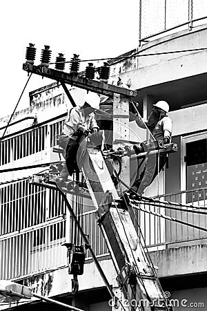 Silhouette electrician working on electricity post