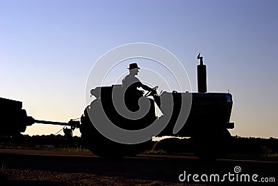 Silhouette of farmer on tractor