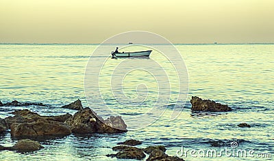 Silhouette of a fisherman in the calm sea.