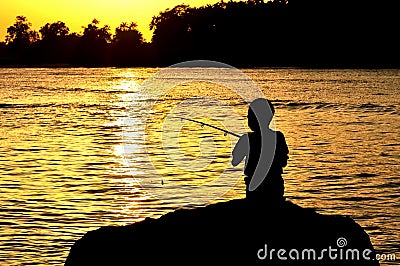 Silhouette of kid fishing