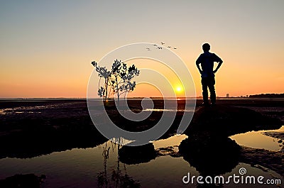 Silhouette of Man looking to the sun near the beach