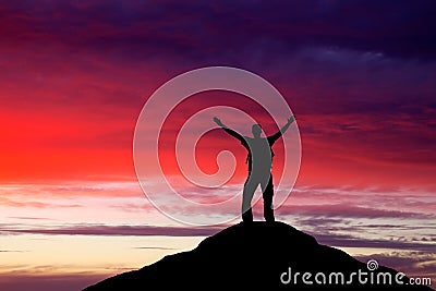Silhouette of a man on a mountain top.