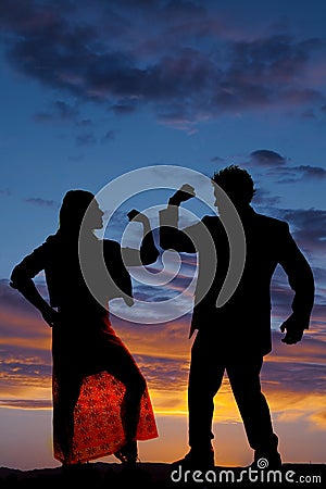 Silhouette man woman facing each other both flex one arm