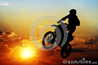Silhouette of a motorcyclist on a background of dark sky