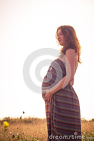 Silhouette of a pregnant woman at sunset
