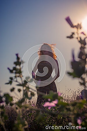 Silhouette of a pregnant woman at sunset