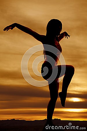 Silhouette woman leg up arms out