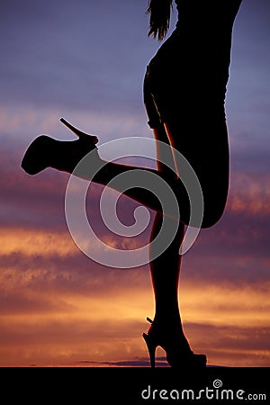 Silhouette woman legs kicked back sunset