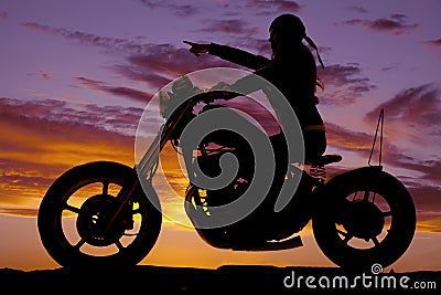Silhouette woman motorcycle ride pointing
