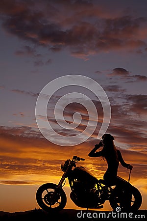 Silhouette of woman motorcycle sit backwards hand