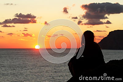 Silhouette of a woman watching beautiful sunset