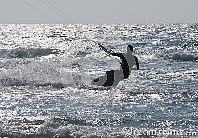 Silhouette of Young Man Kite Boarding in sea Waves