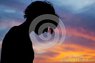 Silhouetted female in front of sunset sky