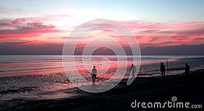 Silhouettes of people playing football on the beach