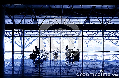 Silhouettes of people waiting at the boarding gates.