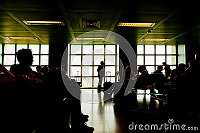 Silhouettes of people waiting at plane boarding gates