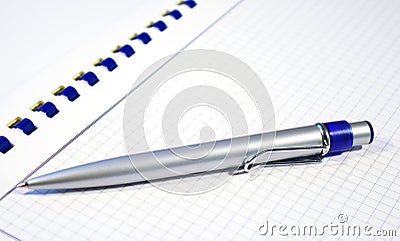 Silver pen and spiral notebook