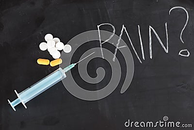 Single syringe and pills on chalkboard with pain