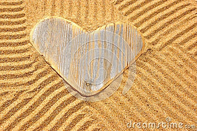 Single wooden love heart in the sand