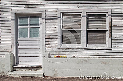 Six apples on the front wall of an old wooden hous