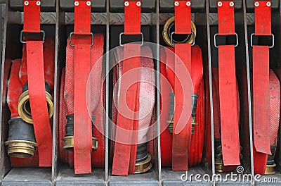 Six red hoses of firefighters in order inside the fire truck