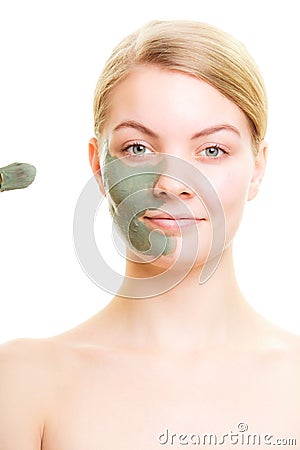 Skin care. Woman applying clay mud mask on face.