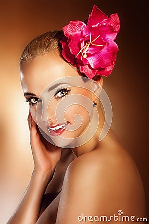 Closeup beautiful young woman face with flower. Girl smiling.