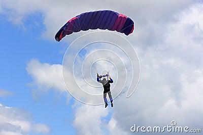 Skydiver parachuting down to the Earth.