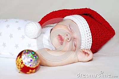 Sleeping baby in New Year s hat and Christmas-tree decoration