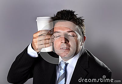 Sleepy addict businessman holding take away coffee in caffeine addiction