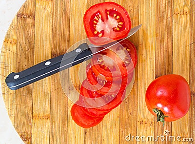 Sliced ​​tomatoes with a knife on a board