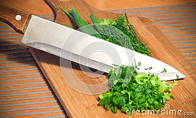 Sliced greens with knife on cutting board