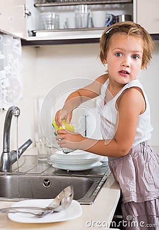 Small girl chores washing dishes