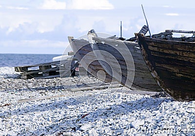 Small row boats laying on a pebble beach