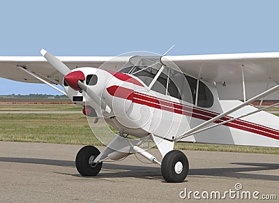 Small tail-wheel red and white airplane.