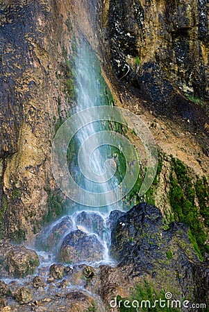 Small waterfall on highly textured rock and moss